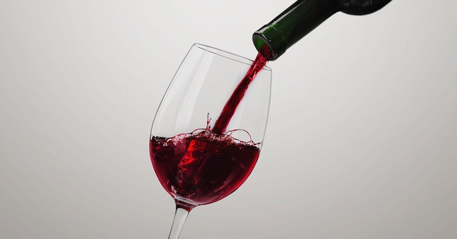 In ein Glas wird Wein eingeschenkt. © Shutterstock